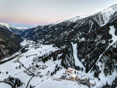 Jesacherhof: Ihr Hotel im Defereggental Verschneites Alpental mit Dörfern, Wald und Bergen bei Sonnenuntergang