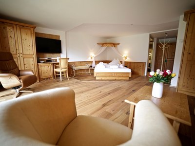 Give the gift of joy: the hotel in East Tyrol with wellness Cozy hotel room with wooden furniture, double bed and seating area