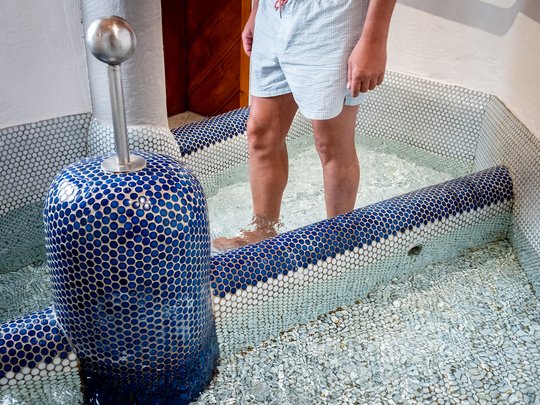 Accommodation in St. Jakob in Defereggental: healing water Person standing in Kneipp basin with blue tiles and water up to calves