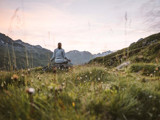Jesacherhof: Ihr Hotel im Defereggental Person meditiert in den Bergen bei Sonnenuntergang