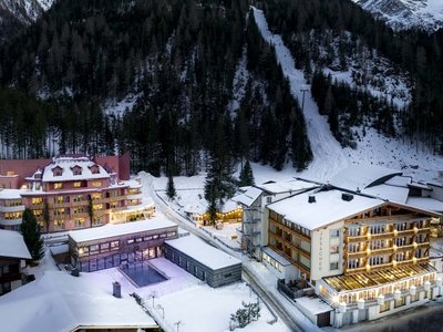 Give the gift of joy: the hotel in East Tyrol with wellness Snow-covered alpine hotels with forest and mountain backdrop at dusk