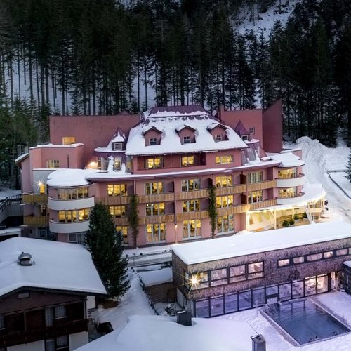 A holiday in St. Jakob in Defereggental Snow-covered alpine hotels with forest and mountain backdrop at dusk